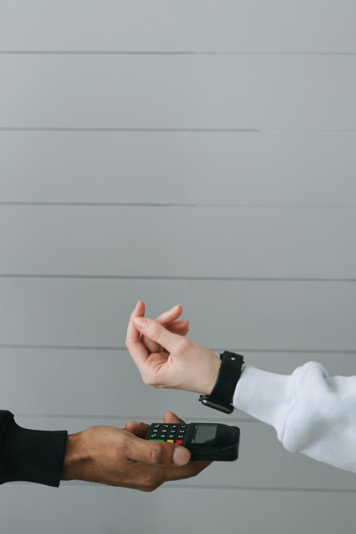 Close-up of a smartwatch being used for a contactless payment at a digital card terminal.